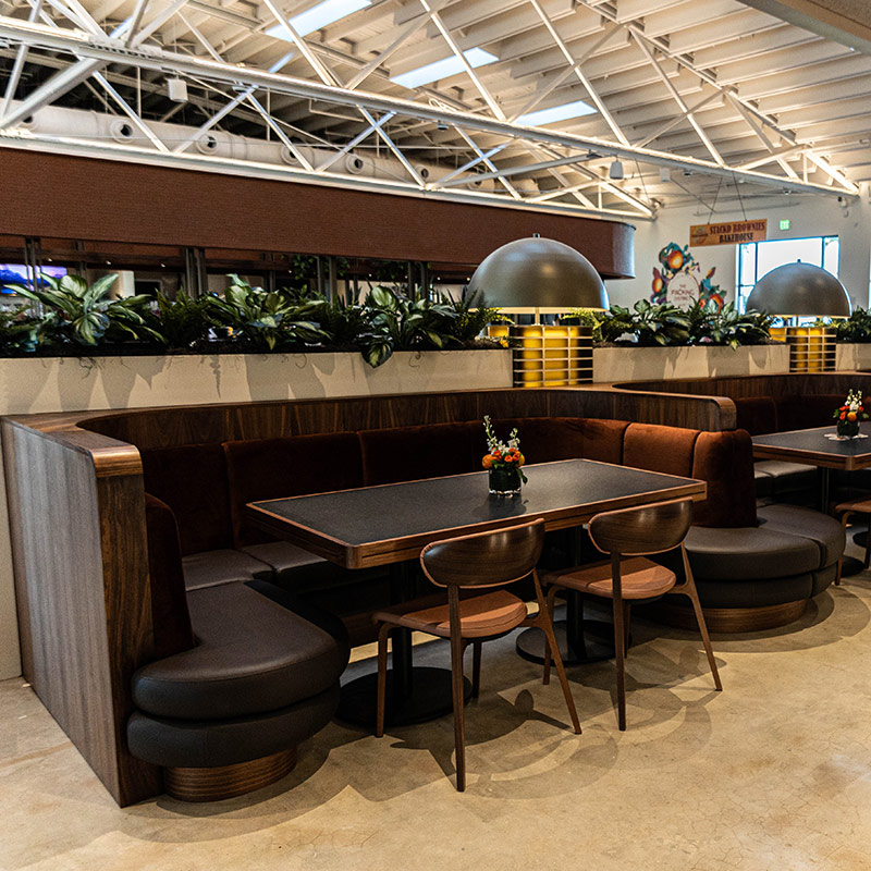 Chairs at a table next to a contemporary bar with industrial chic décor and lighting. 