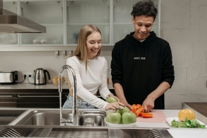 Couple cooking together for National Girlfriend Day.